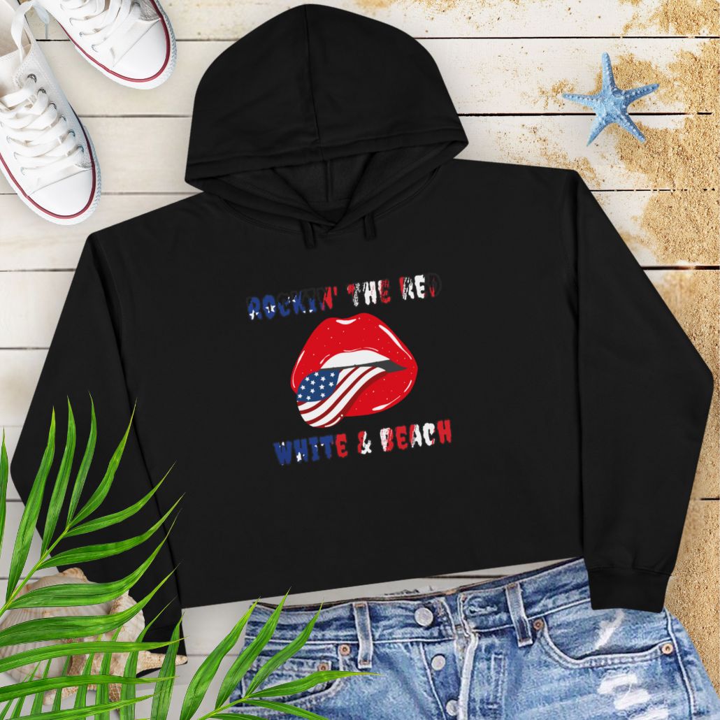 Black Rockin' the Beach Crop Hoodie - Patriotic Fashion for Summer Celebrations Hoodie featuring rolling stone lips with an American flag tongue and text that says Rockin' the Red White and Blue that has a gradient of the flag inside.