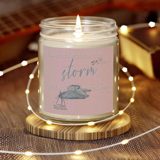 9 oz Scented Clear Jar candle featuring label with a sailboat design and the inspirational phrase 'Sail Through the Storm with a Steady Flame,' making it the perfect addition to any nautical or coastal-themed home decor.