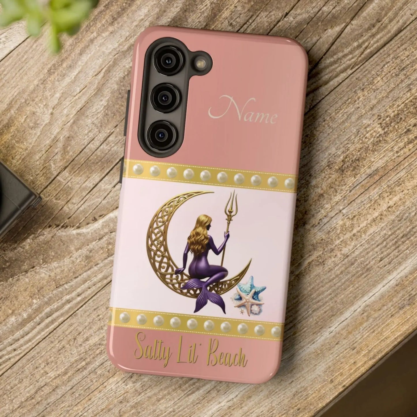 Pink and White Samsung Galaxy S23 Cell Phone Case with mermaid sitting on a celtic crescent moon holding a trident that says Salty Lil' Beach. Personalized with name.
