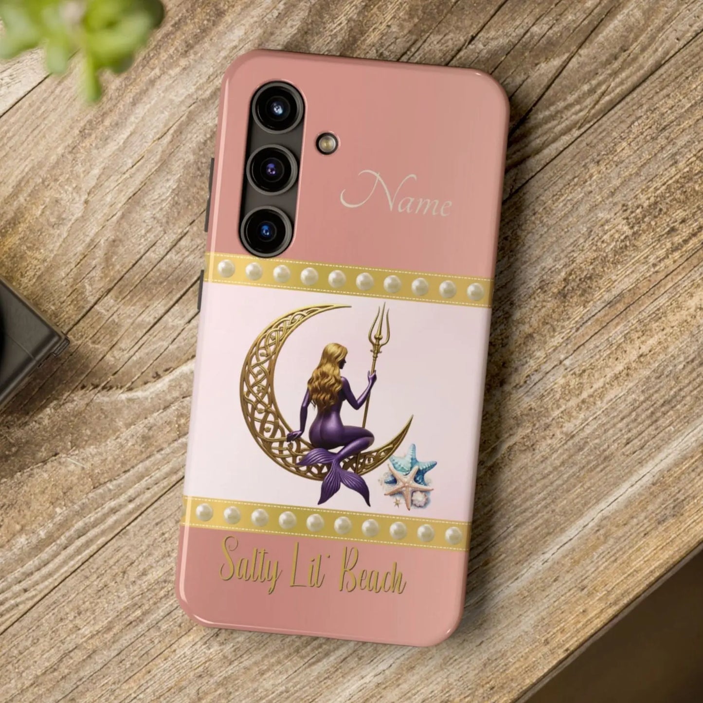 Pink and White Samsung Galaxy S24 Cell Phone Case with mermaid sitting on a celtic crescent moon holding a trident that says Salty Lil' Beach. Personalized with name.