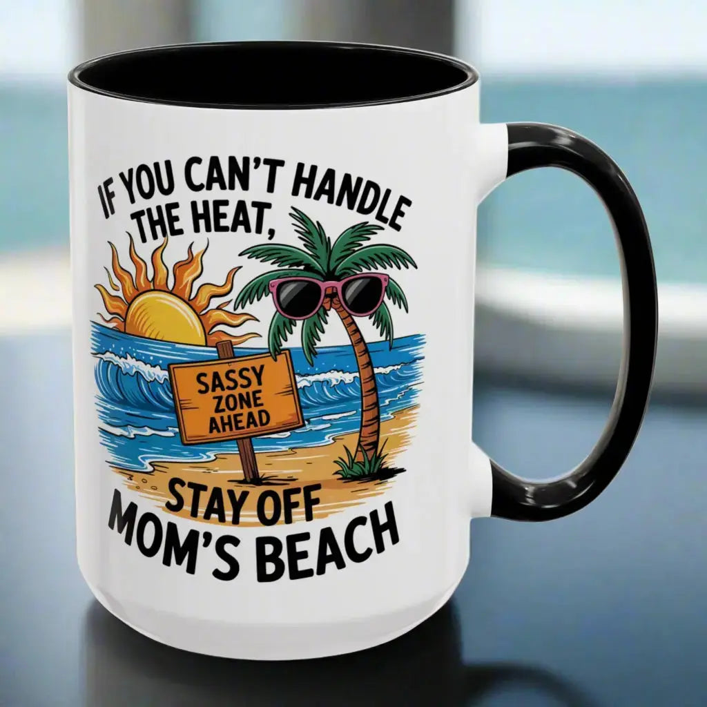 A white 15 oz mug with a black handle and inside with a beach scene and a beach sign that says Sassy Zone Ahead with the text If You Can't Handle the Heat Stay Off Mom's Beach.