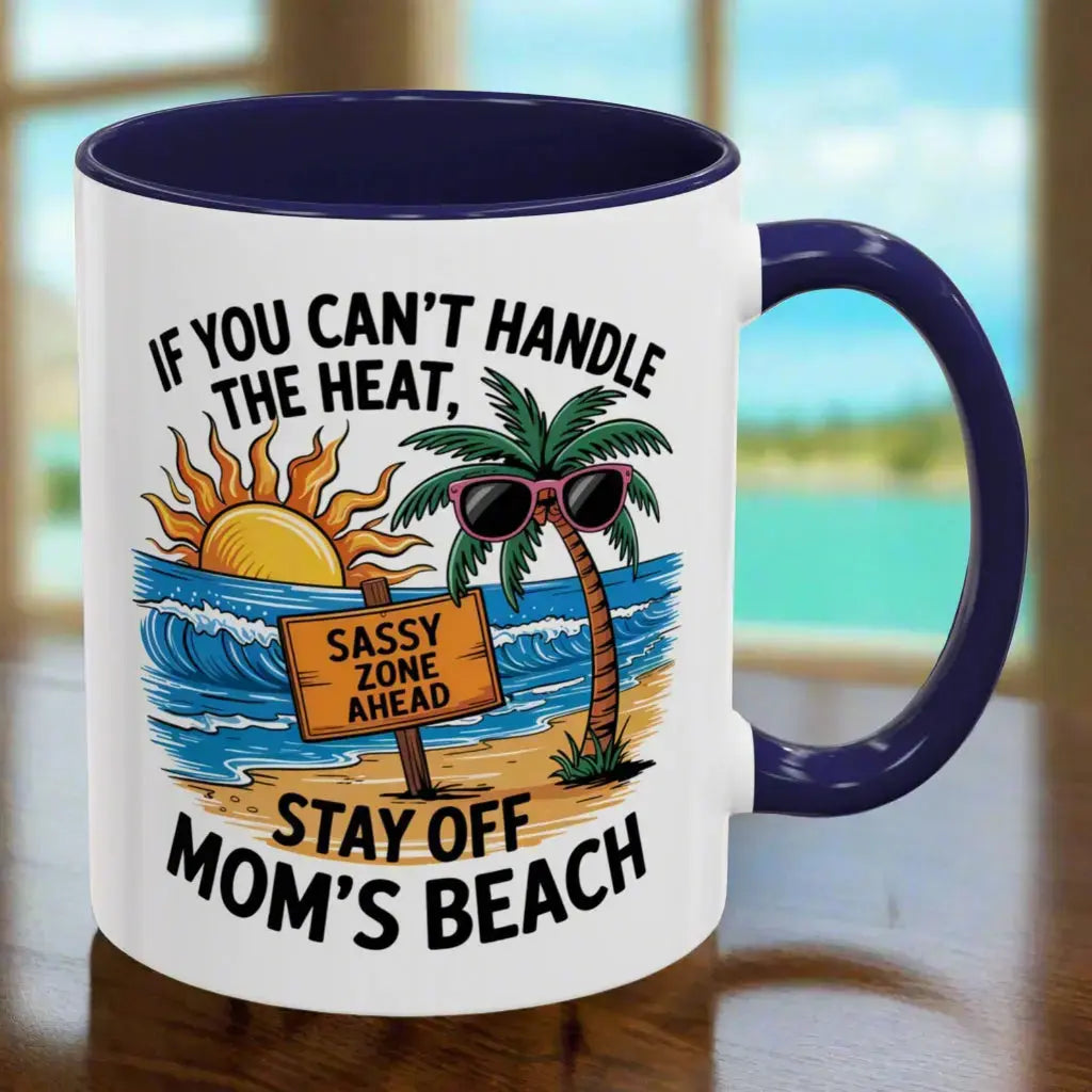 A white 11 oz mug with a navy handle and inside with a beach scene and a beach sign that says Sassy Zone Ahead with the text If You Can't Handle the Heat Stay Off Mom's Beach.