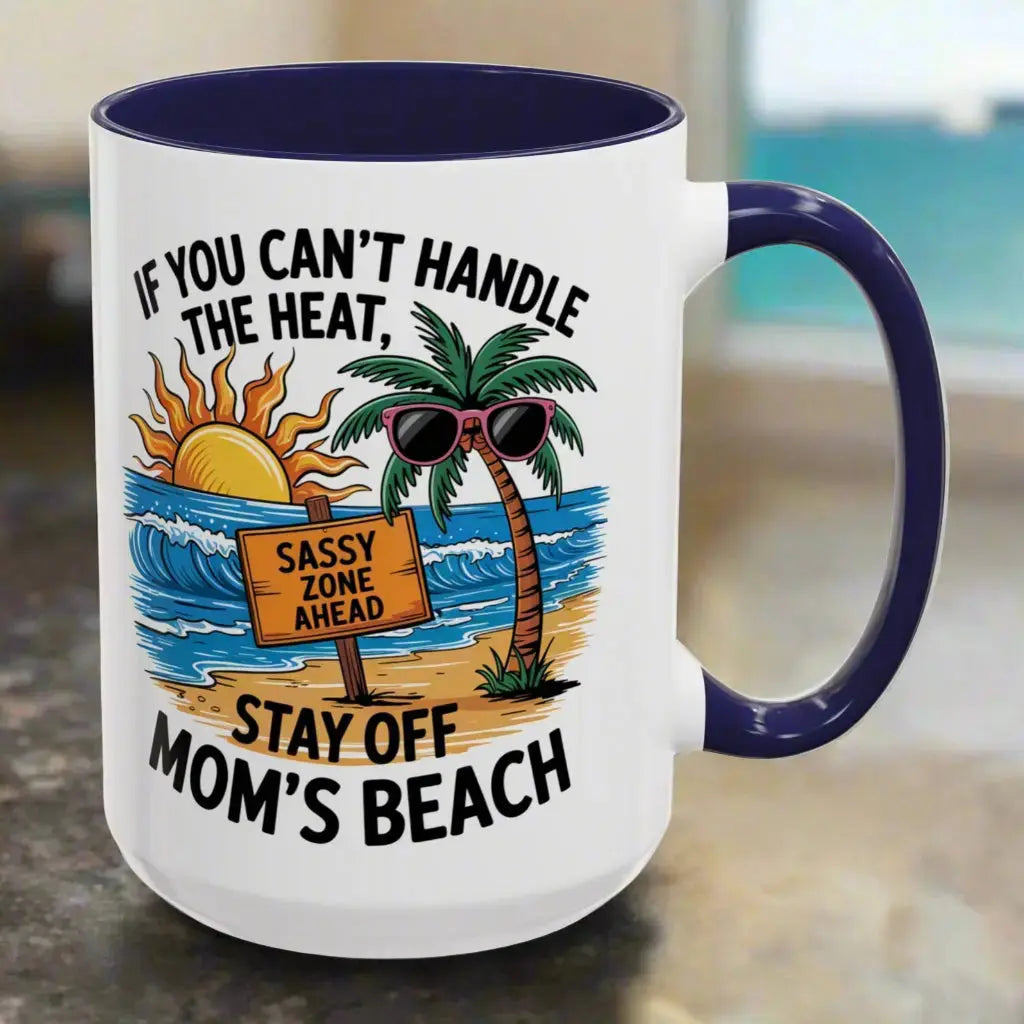 A white 15 oz mug with a navy handle and inside with a beach scene and a beach sign that says Sassy Zone Ahead with the text If You Can't Handle the Heat Stay Off Mom's Beach.