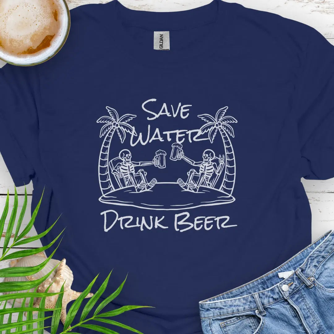 Navy T-shirt featuring two skeletons on a beach clinking beer bottles with the phrase "Save Water Drink Beer" in a playful coastal setting.