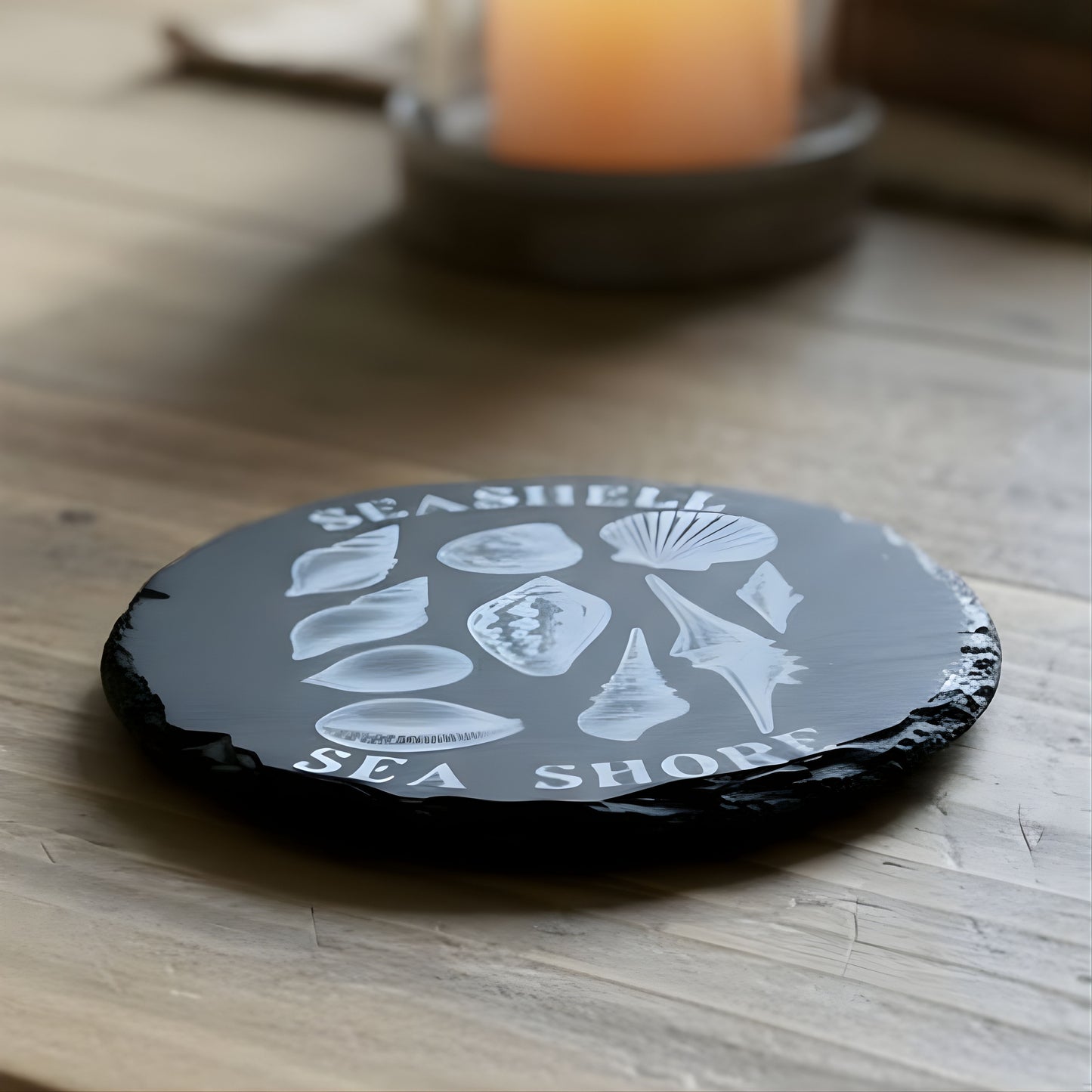 Black coaster with white shell design and 'Seashell Sea Shores' text engraved.