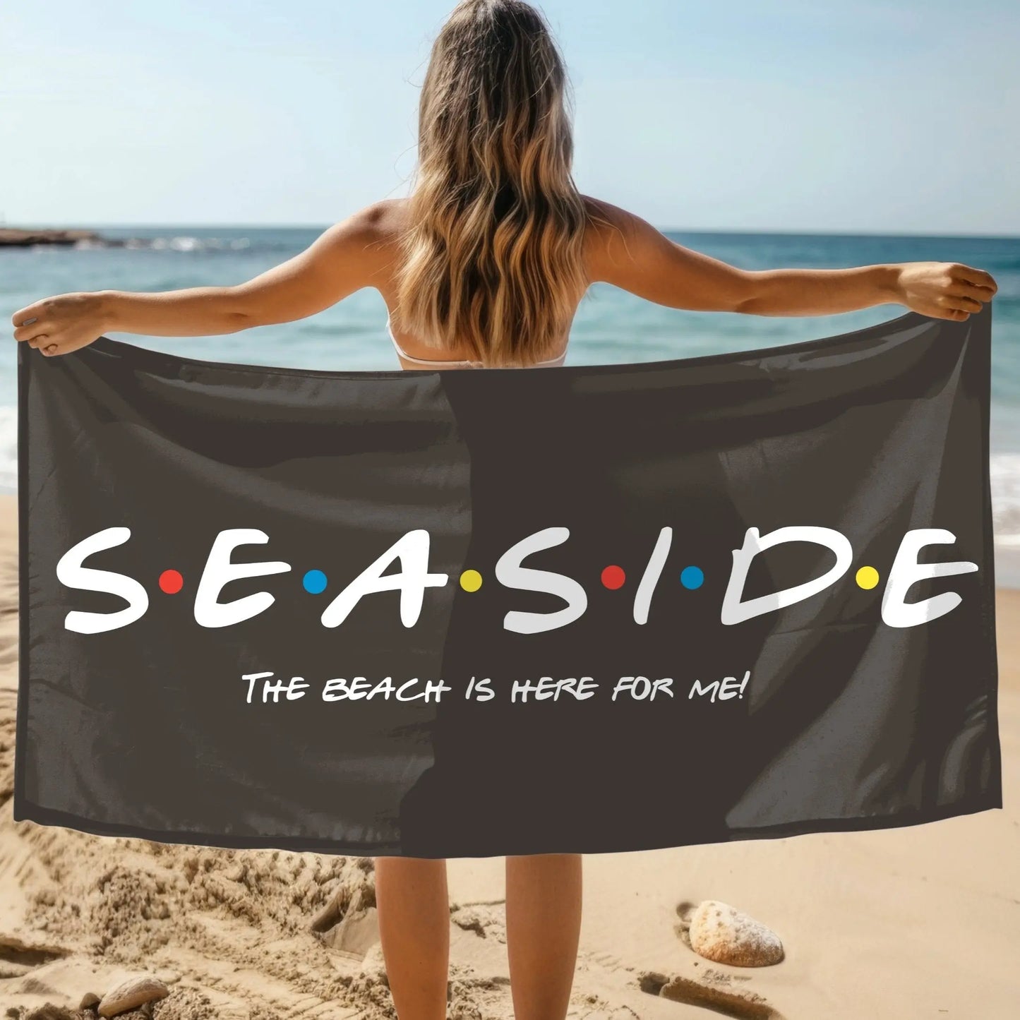 Black beach towel that says Seaside with colored dots in between and says The Beach is Here for Me