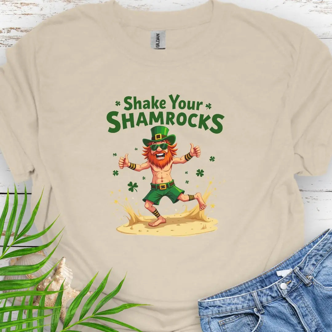 Shop our fun and festive dancing leprechaun in beach attire with shamrock confetti with the text 'Shake Your Shamrocks' Sand Colored T-shirt! Perfect for St. Patrick's Day celebrations or anyone who loves a touch of whimsy in their wardrobe.