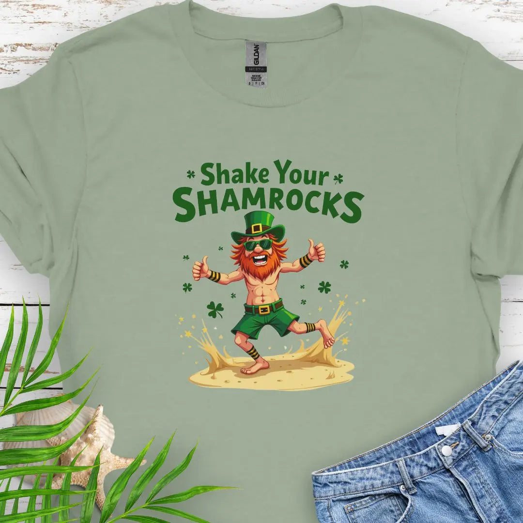 Shop our fun and festive dancing leprechaun in beach attire with shamrock confetti with the text 'Shake Your Shamrocks' Sage T-shirt! Perfect for St. Patrick's Day celebrations or anyone who loves a touch of whimsy in their wardrobe.