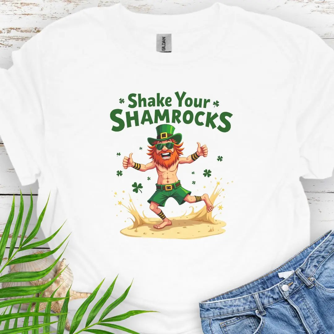 Shop our fun and festive dancing leprechaun in beach attire with shamrock confetti with the text 'Shake Your Shamrocks' White T-shirt! Perfect for St. Patrick's Day celebrations or anyone who loves a touch of whimsy in their wardrobe.