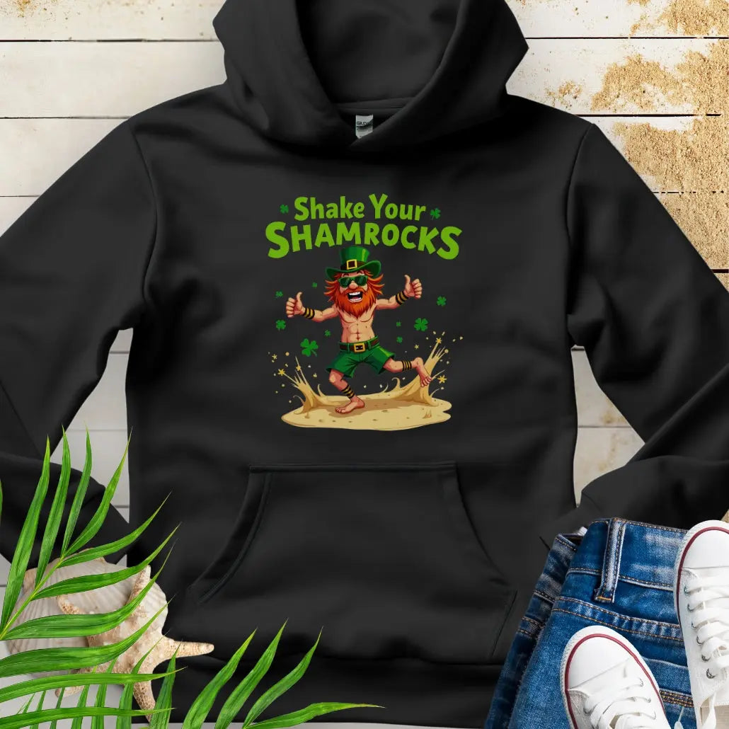 Shop our fun and cozy dancing leprechaun in beach attire with shamrock confetti with the text 'Shake Your Shamrocks' Black Hoodie! Perfect for St. Patrick's Day celebrations or anyone who loves a touch of whimsy in their wardrobe.