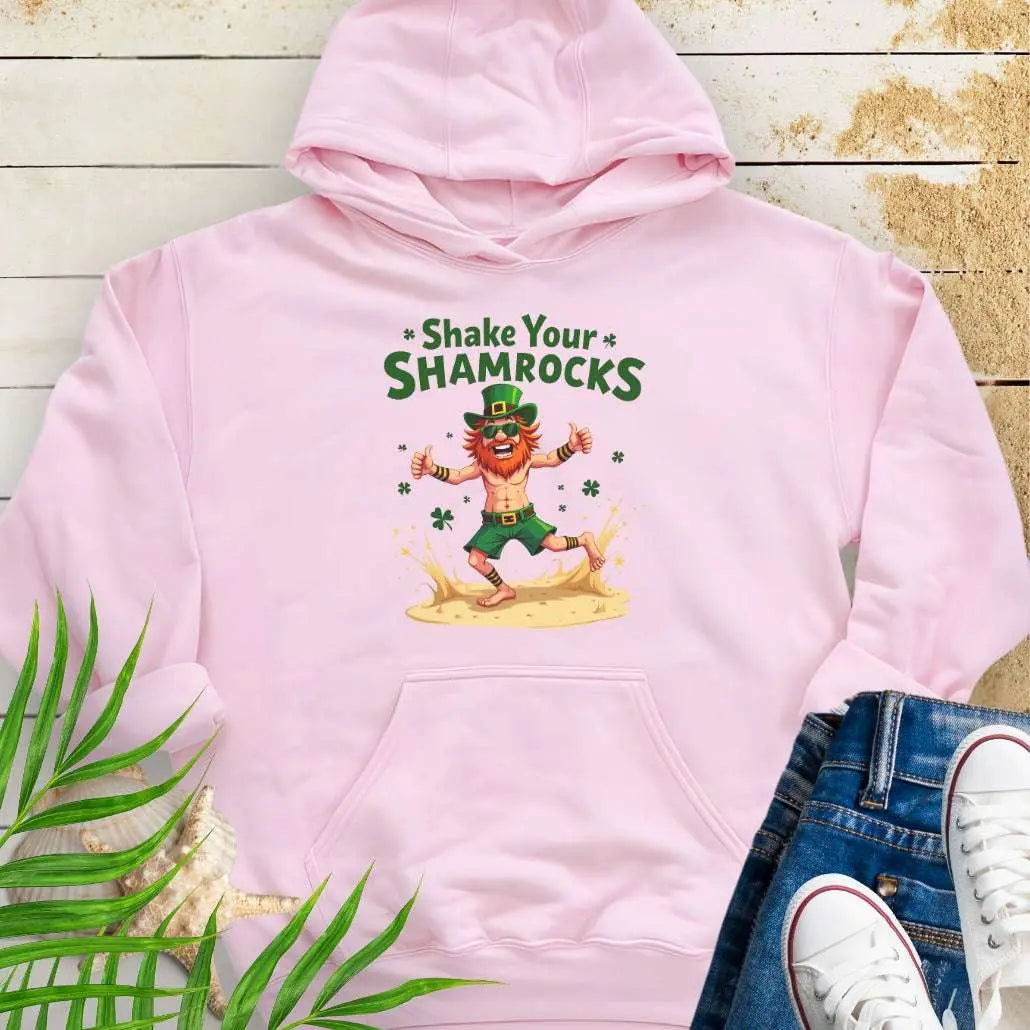 Shop our fun and cozy dancing leprechaun in beach attire with shamrock confetti with the text 'Shake Your Shamrocks' Light Pink Hoodie! Perfect for St. Patrick's Day celebrations or anyone who loves a touch of whimsy in their wardrobe.