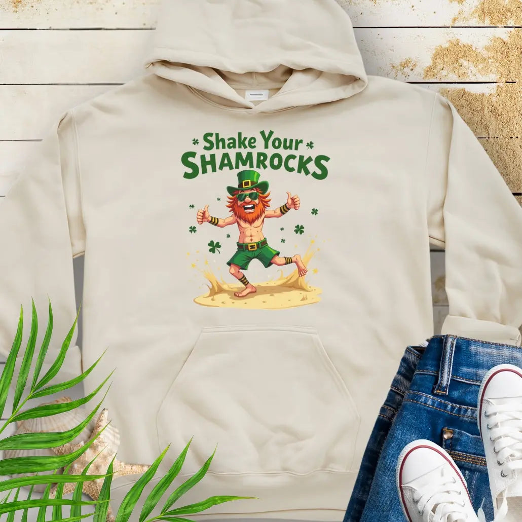 Shop our fun and cozy dancing leprechaun in beach attire with shamrock confetti with the text 'Shake Your Shamrocks' Sand colored Hoodie! Perfect for St. Patrick's Day celebrations or anyone who loves a touch of whimsy in their wardrobe.