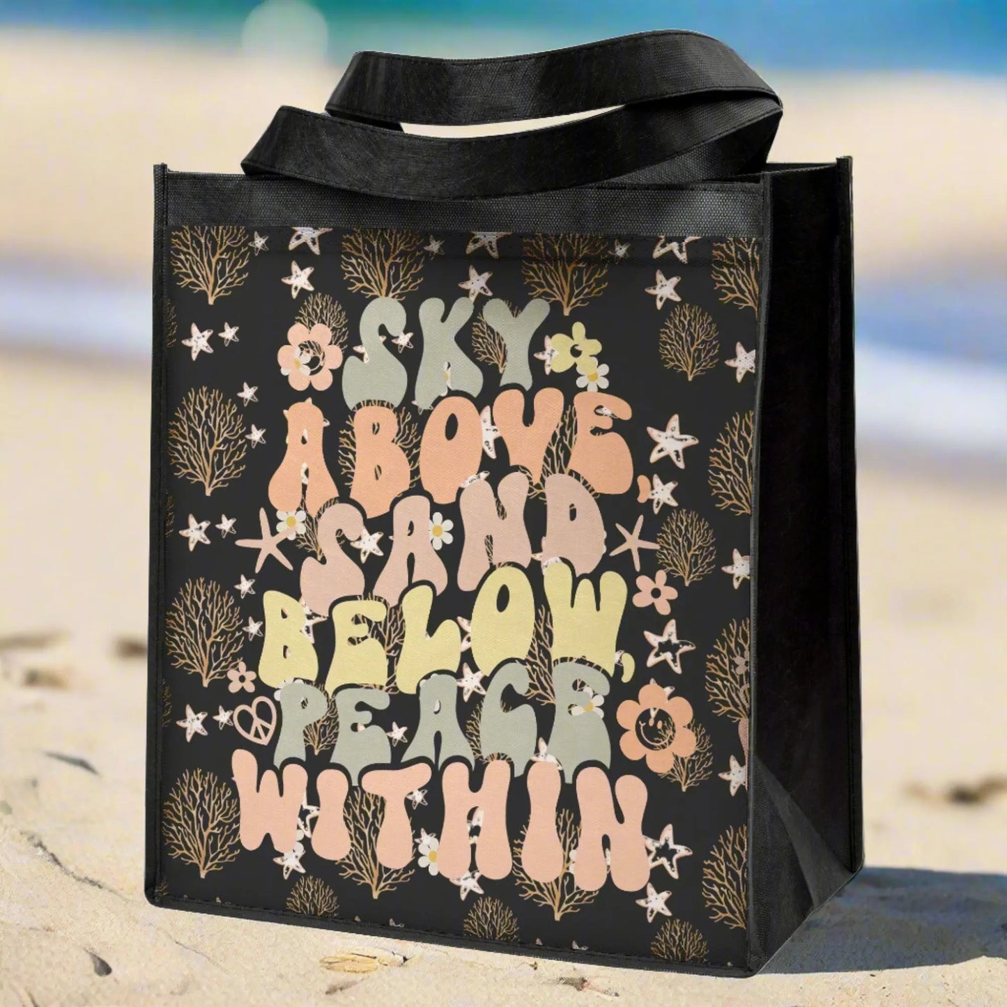 Black grocery bag with ocean foliage and starfish in tan colors with retro text that says sky above sand below peace within