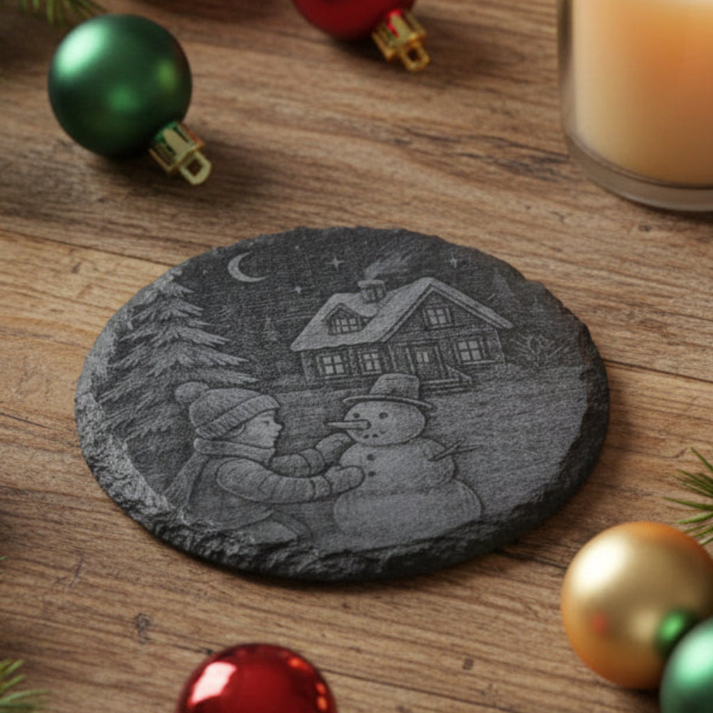Decorative stone with a winter scene of a boy making a snowman and a house in the background.