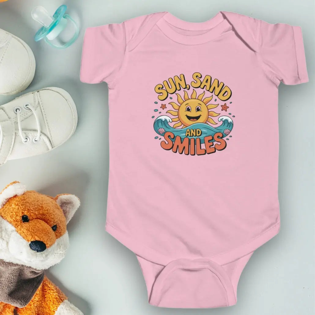 Pink One-piece short-sleeved infant bodysuit with a smiley sun and waves that says Sun, Sand and Smiles.