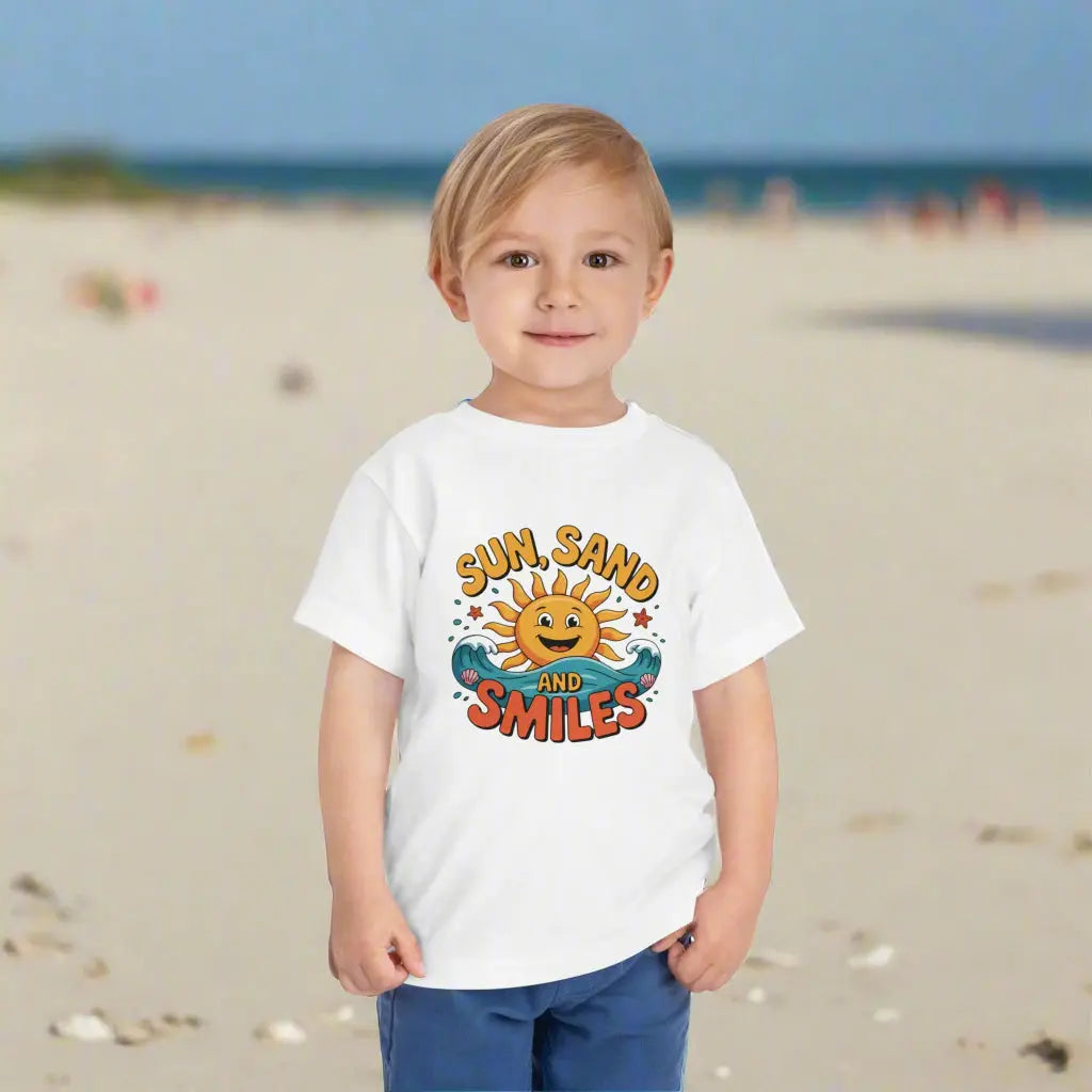 A child wearing a White Toddler T-shirt with a smiling sun and waves that says Sun, Sand and Smiles.