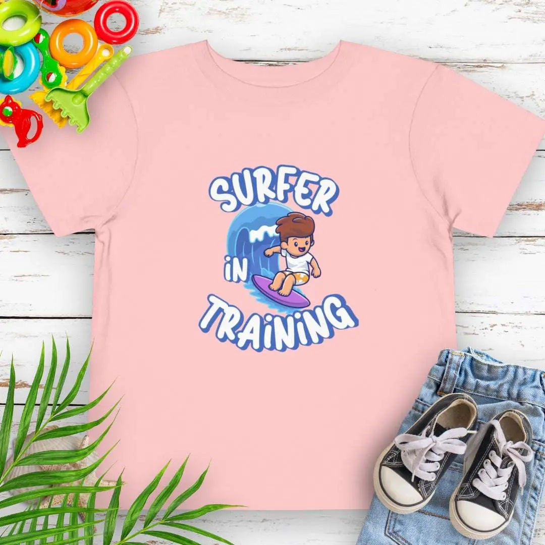 Surfer in Training Toddler's White T-shirt featuring a child surfing.