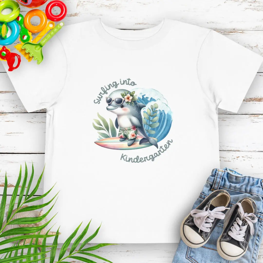 Surfing Into Kindergarten White Toddler's T-shirt with a fun dolphin surfing.