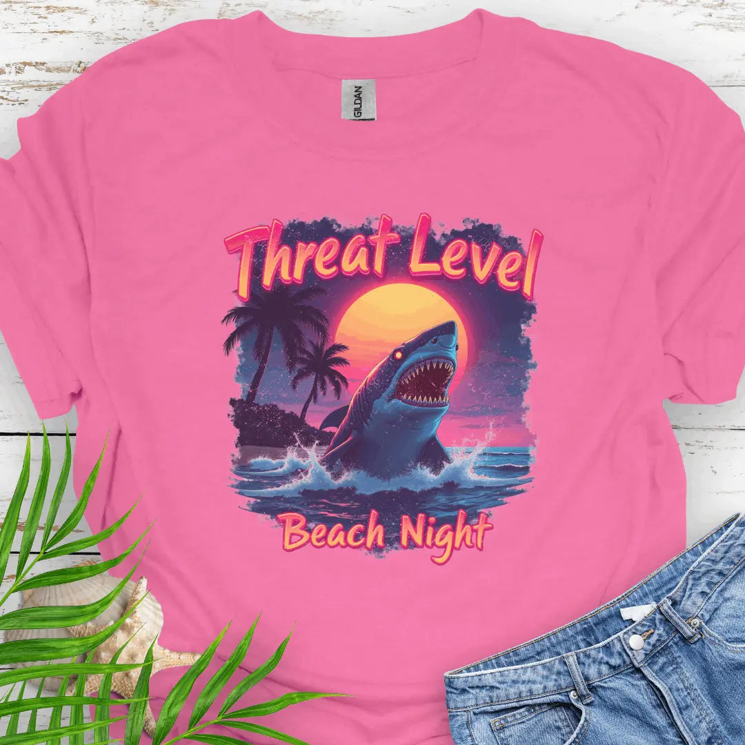 Azalea T-shirt with the words Threat Level Beach Night and a shark coming out of the ocean with a bright moon background in a retro 80's movie poster vibe.