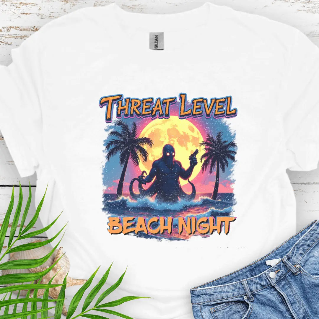 White T-shirt with the words Threat Level Beach Night and an octopus villain coming out of the ocean with a bright moon background in a retro 80's movie poster vibe.