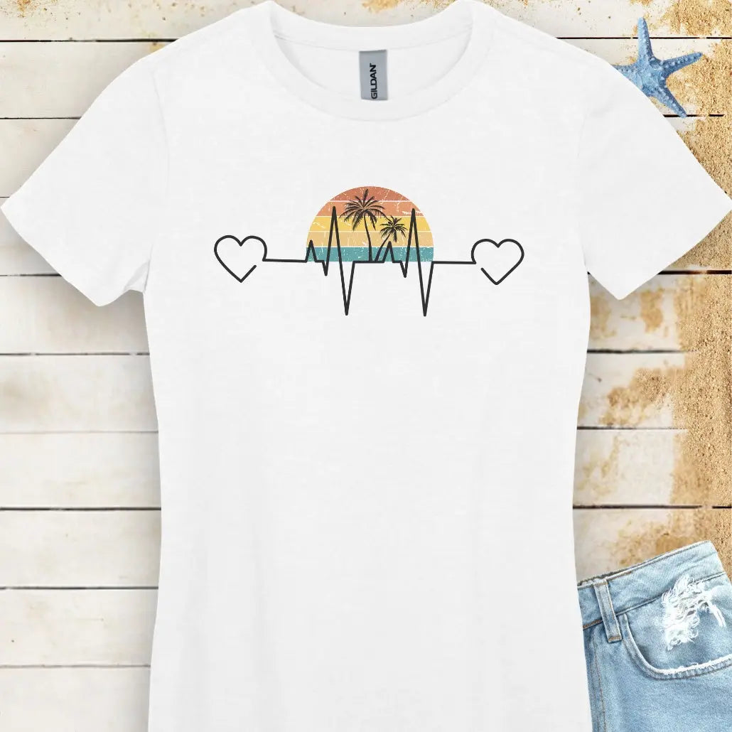 Stay comfy in this white women's T-shirt featuring a retro sunset and heartline design with hearts at both ends. "Tropical Pulse" text adds a beachy, laid-back vibe.