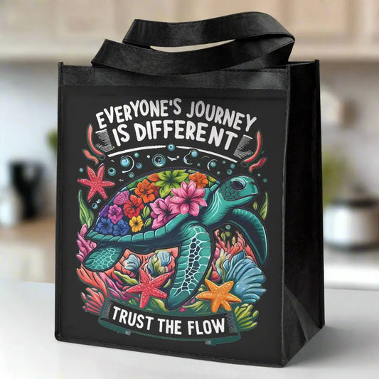 Eco-friendly black grocery tote bag with a vibrant sea turtle design and “Trust the Flow” message.