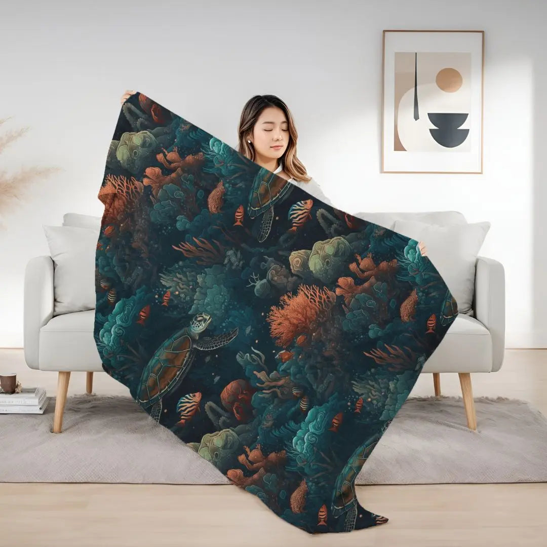 Our Velveteen Plush Blanket with a dark underwater scene with coral, fish and sea turtles.
