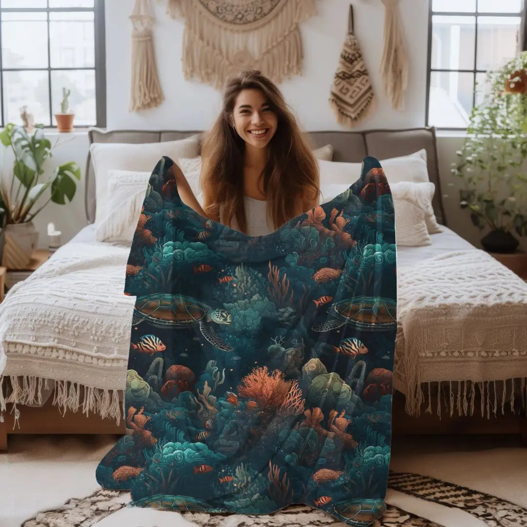 Our Velveteen Plush Blanket with a dark underwater scene with coral, fish and sea turtles.