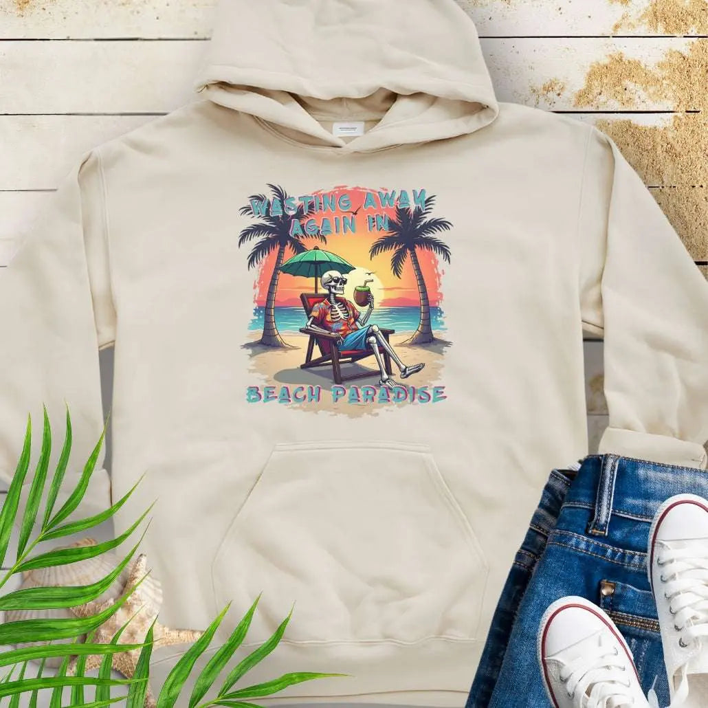 A Sand Hoodie with a skeleton in a Hawaiian Shirt sitting under a beach umbrella on the beach at sunset with a coconut drink between two palm trees that says Wasting Away in Beach Paradise.