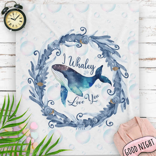 White Velveteen Plush blanket with blue marine plant wreath with swimming whale in the middle and text I Whaley Love You.