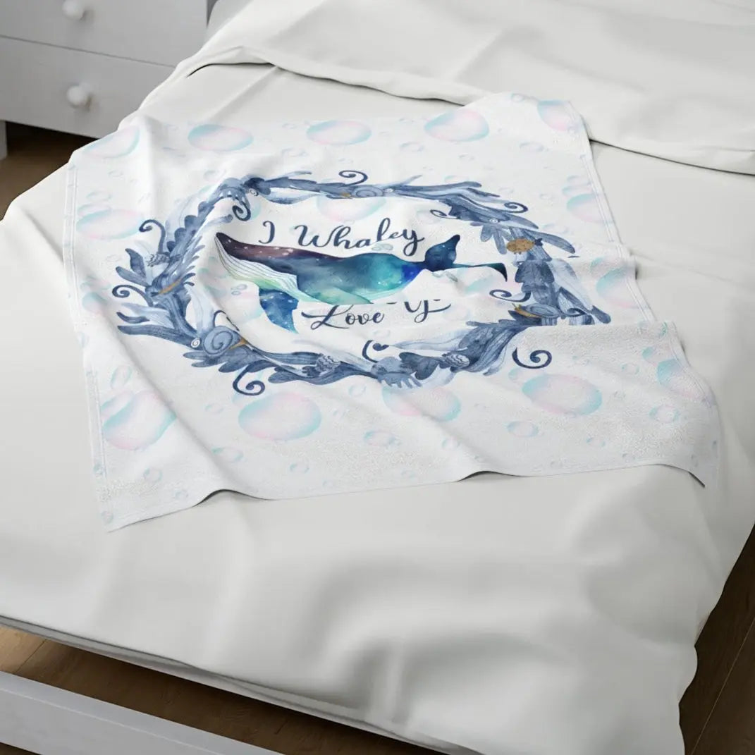 White Velveteen Plush blanket with blue marine plant wreath with swimming whale in the middle and text I Whaley Love You -perfect for snuggling up with your beachy loved ones!