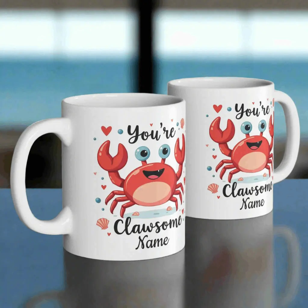 Two white ceramic 11 oz mugs with happy crab with text You're Clawsome personalized with recipient name. Ideal for crab lovers, personalized gift seekers, and those looking to add some fun to their daily beverage enjoyment.