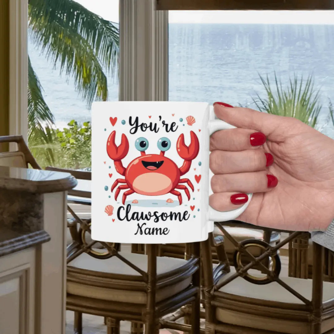 White 11 oz ceramic mug with happy crab with text You're Clawsome personalized with recipient name. Ideal for crab lovers, personalized gift seekers, and those looking to add some fun to their daily beverage enjoyment.