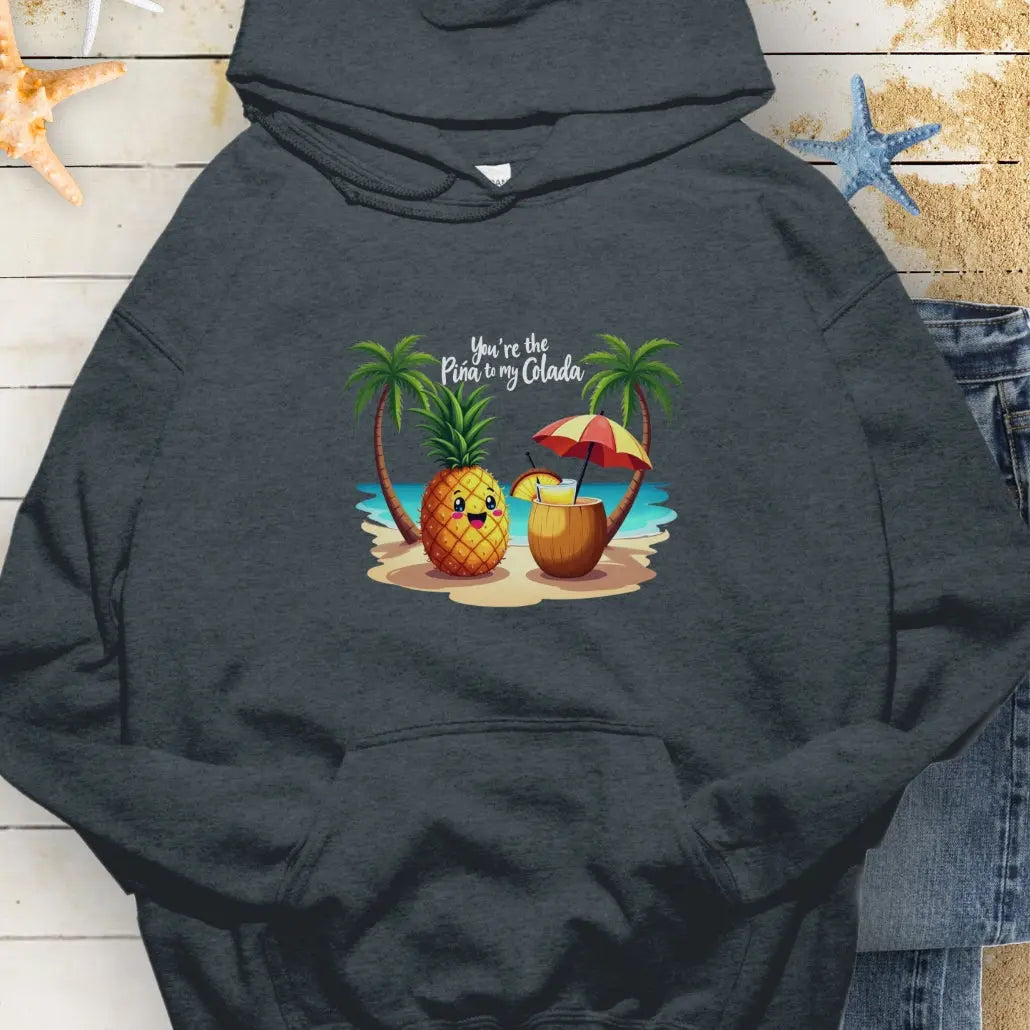 Dark Heather Hoodie with a pineapple and a coconut pina colada on a beach between two palm trees with the text You're the Pina to my Colada.