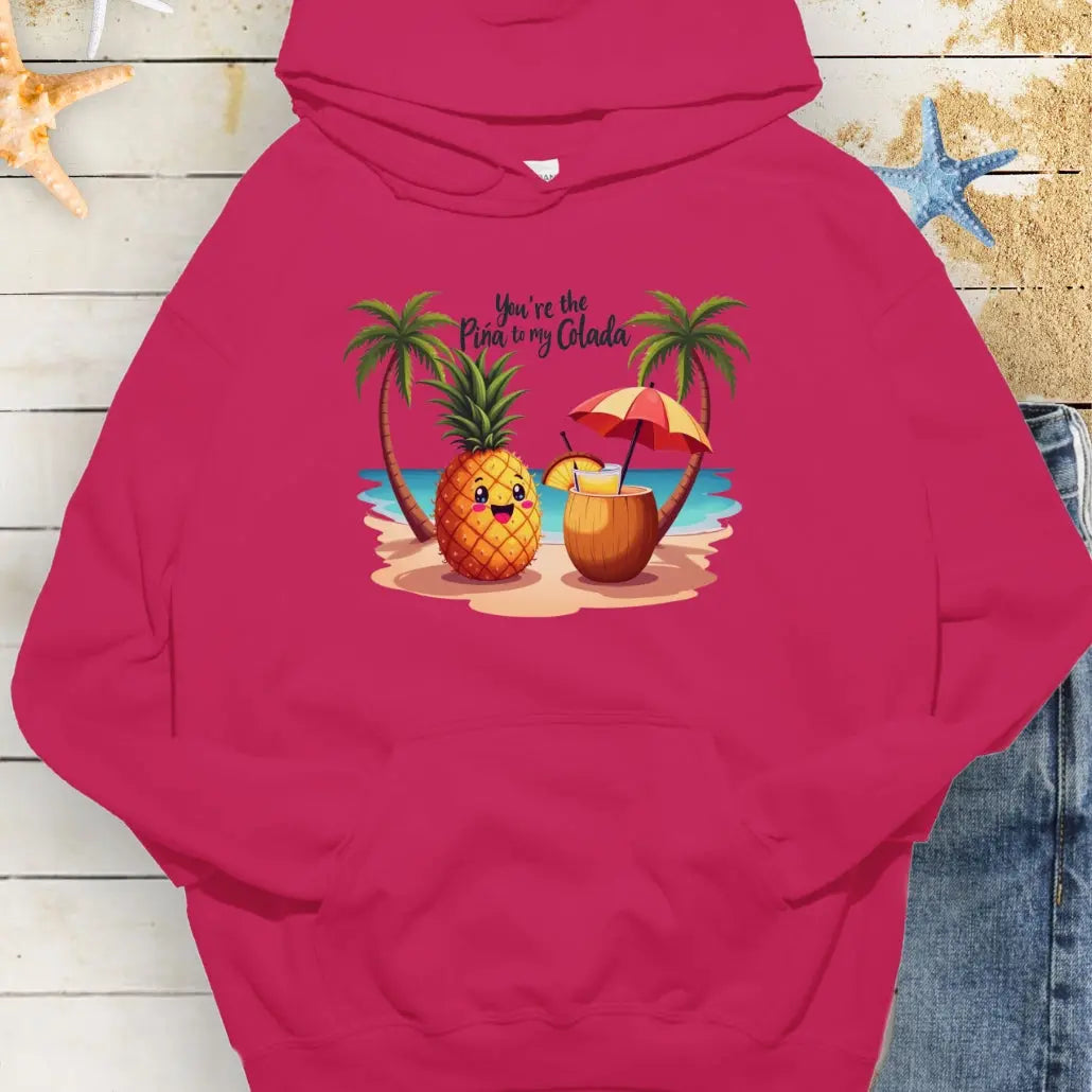 Heliconia Hoodie with a pineapple and a coconut pina colada on a beach between two palm trees with the text You're the Pina to my Colada.