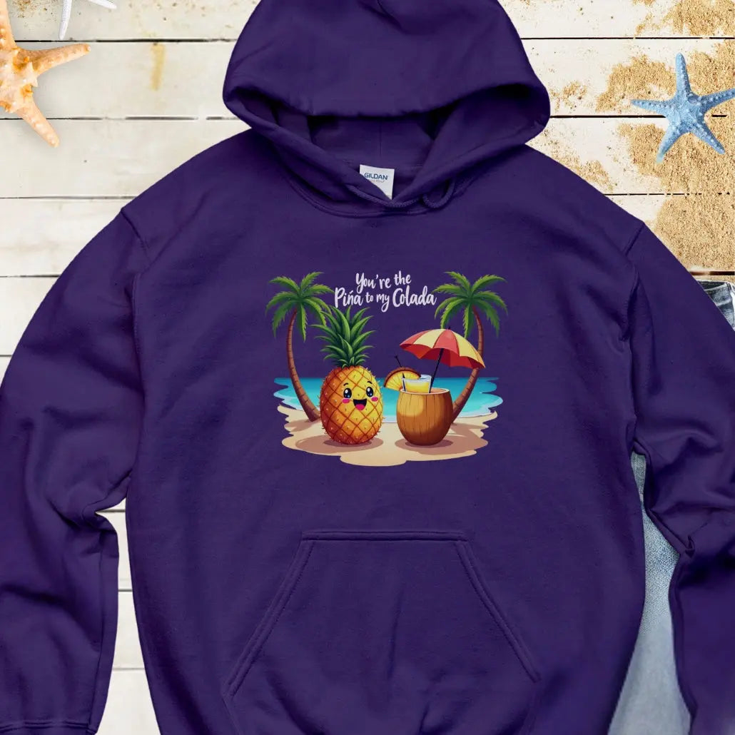 Navy Hoodie with a pineapple and a coconut pina colada on a beach between two palm trees with the text You're the Pina to my Colada.