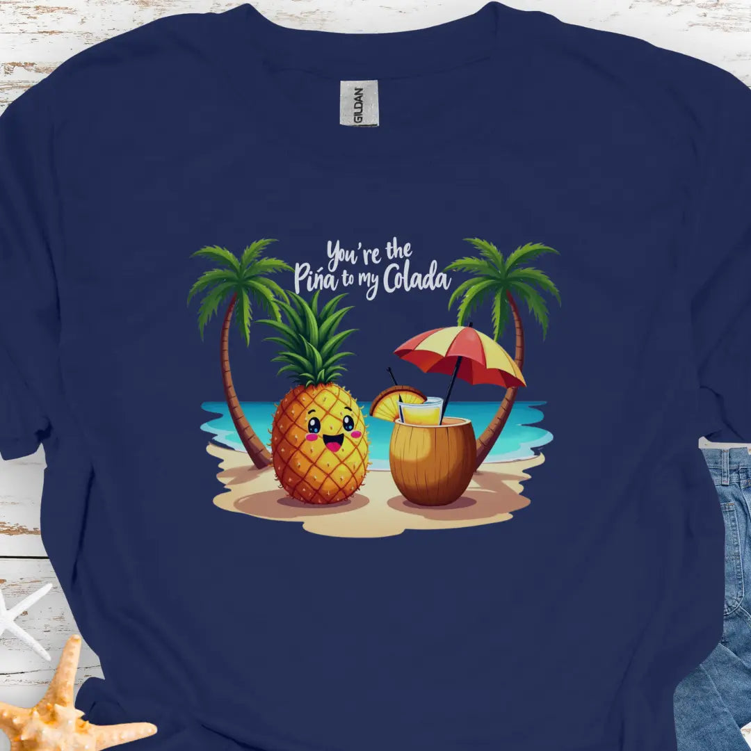 Navy T-shirt with a pineapple and a coconut pina colada on a beach between two palm trees with the text You're the Pina to my Colada.