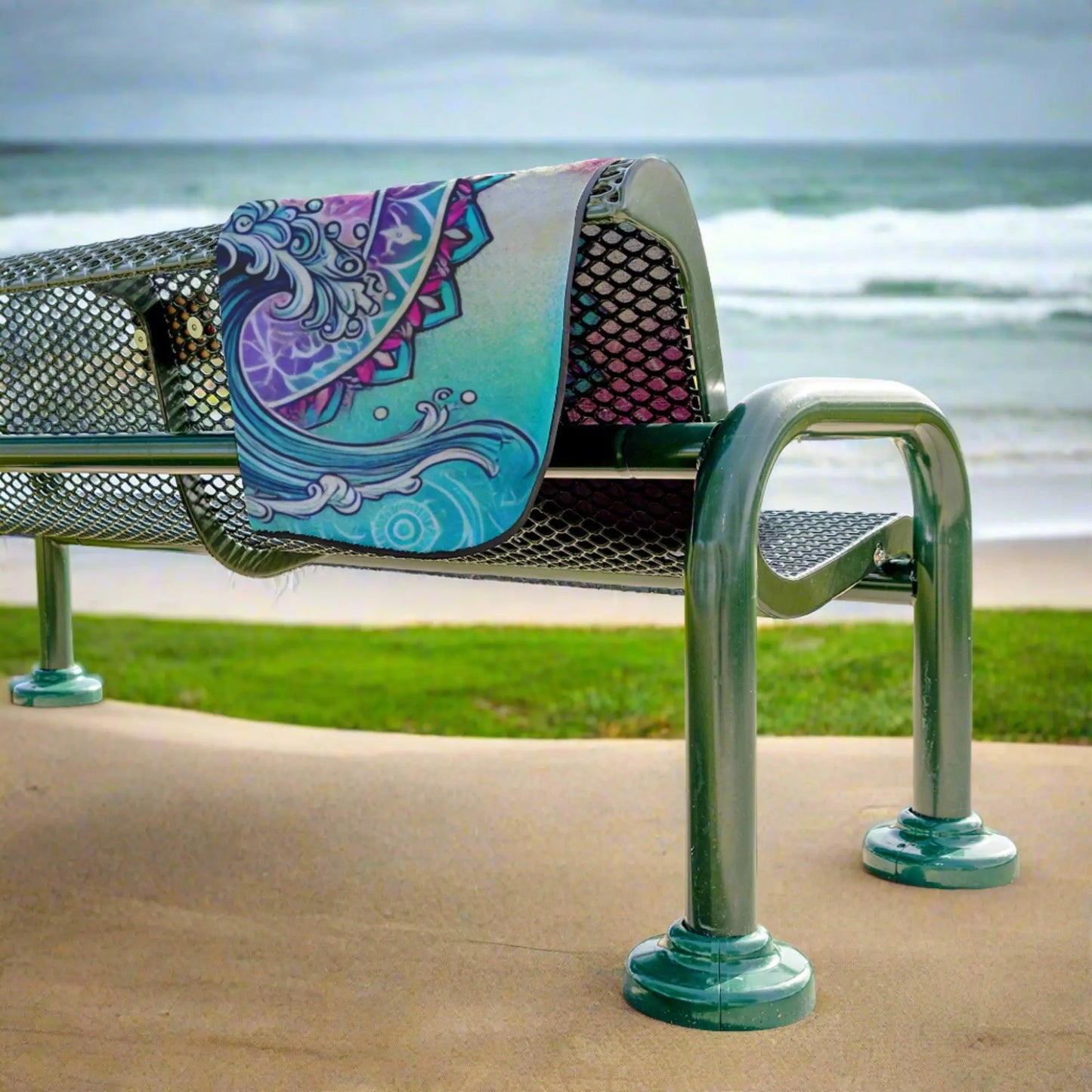 Beach Blanket with waves and dolphin in pink and aqua hanging over bench