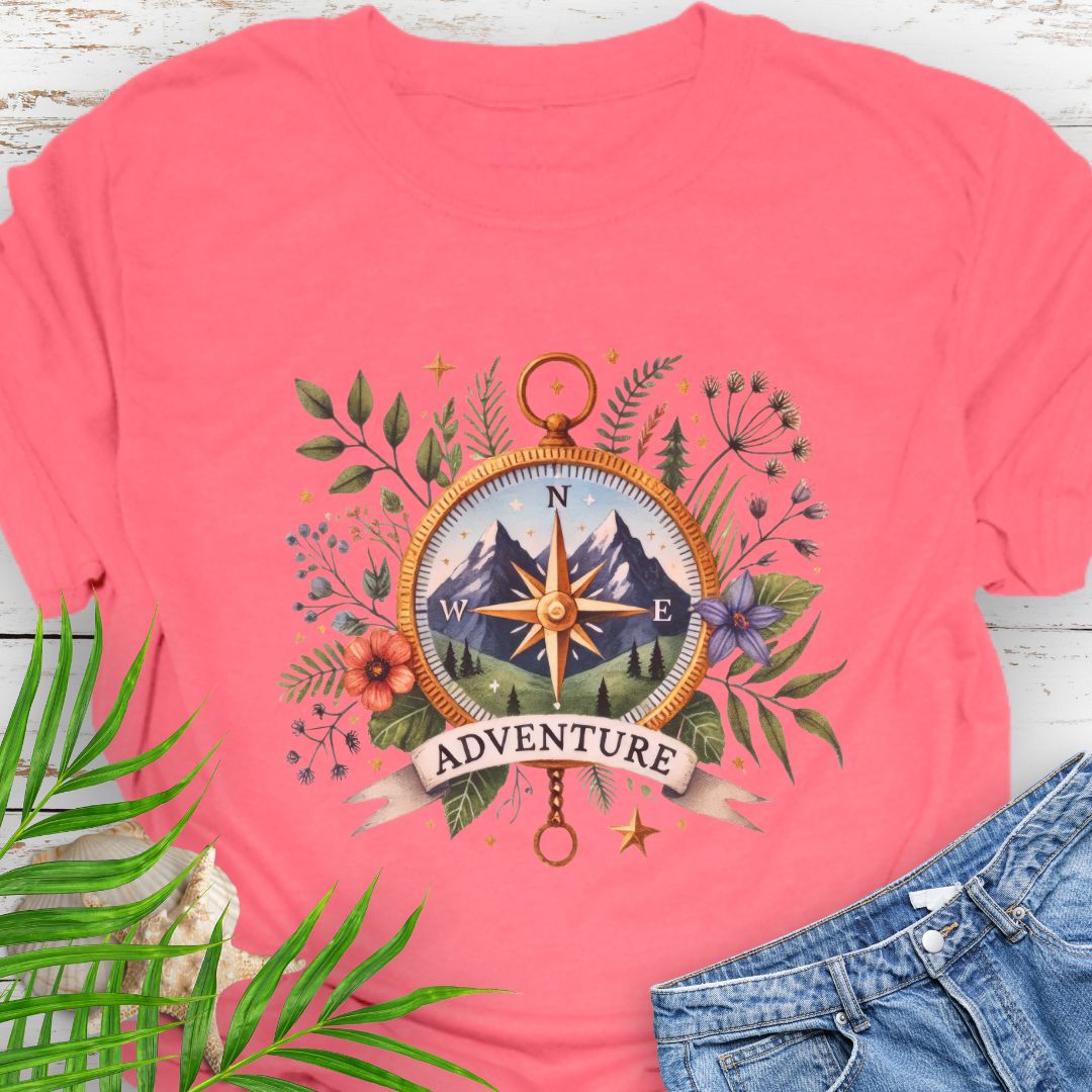 Coral Silk T-shirt with a compass design featuring a mountain scene inside, surrounded by wildflowers and a banner that says "Adventure" – perfect for outdoor enthusiasts.