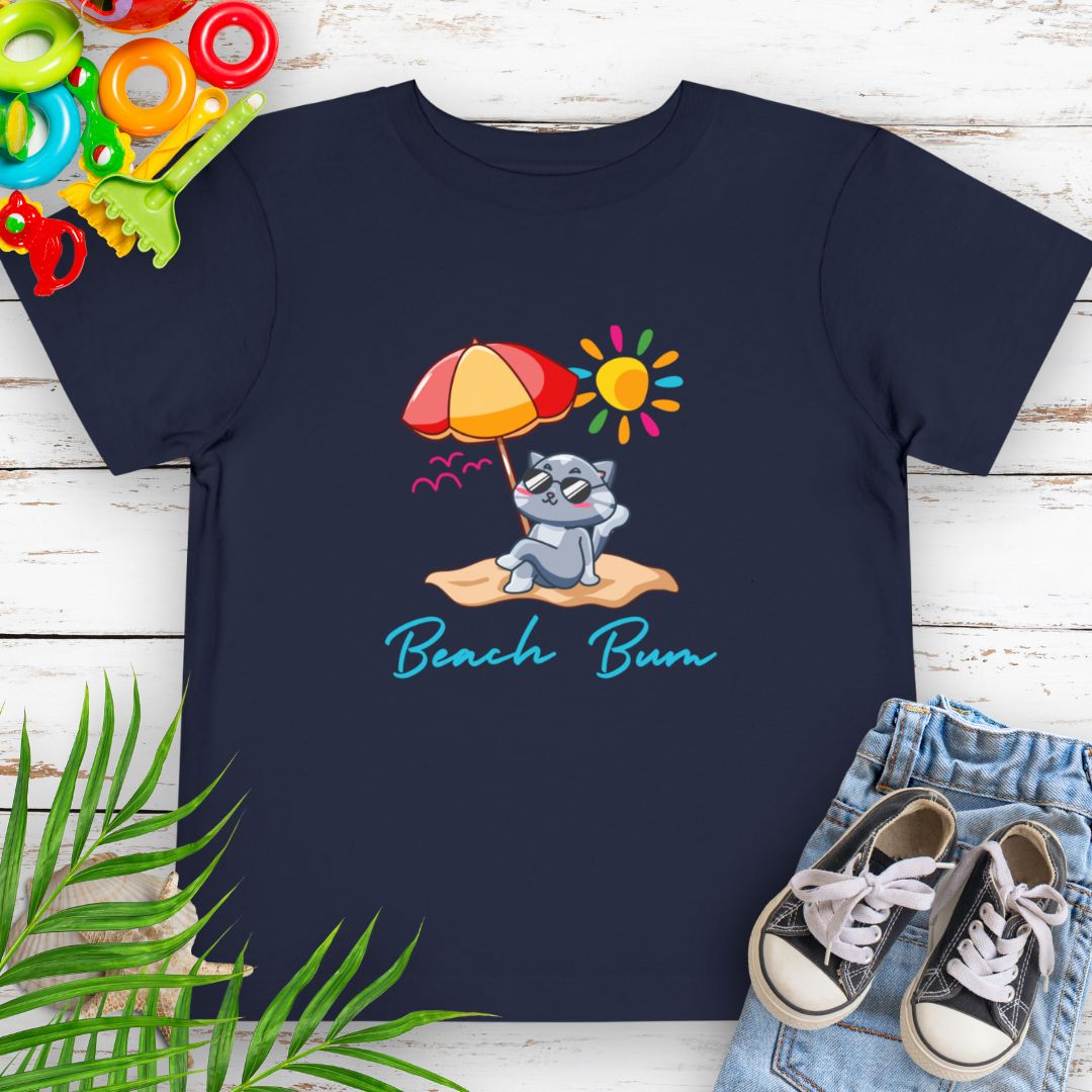 Navy Beach Bum toddler t-shirt with vibrant playful summer design of a cute cat wearing sunglasses laying on the beach under an umbrella.