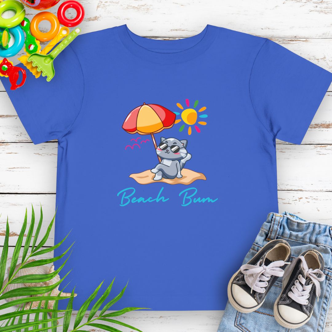 Royal Blue Beach Bum toddler t-shirt with vibrant playful summer design of a cute cat wearing sunglasses laying on the beach under an umbrella.