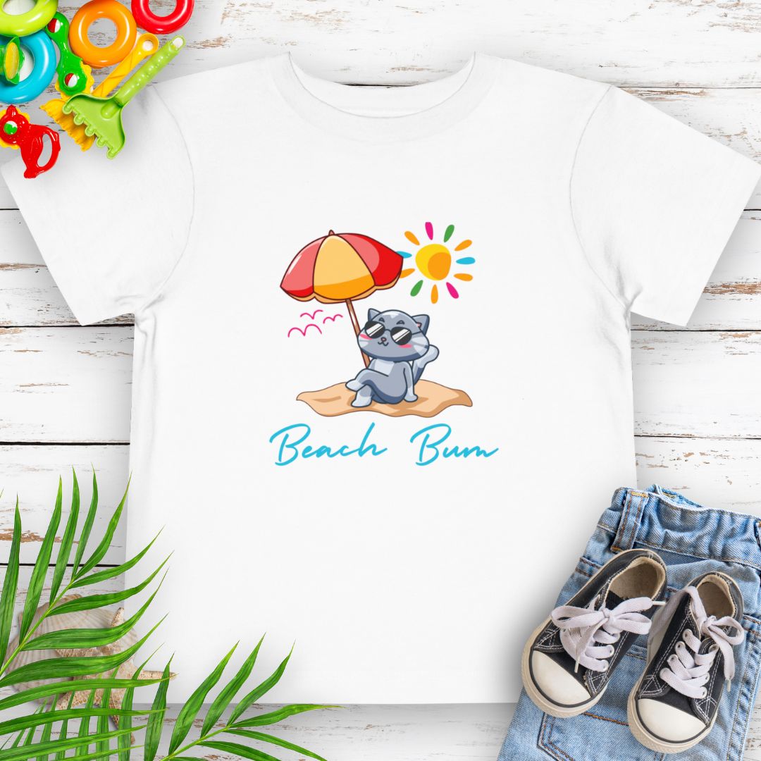 White Beach Bum toddler t-shirt with vibrant playful summer design of a cute cat wearing sunglasses laying on the beach under an umbrella.
