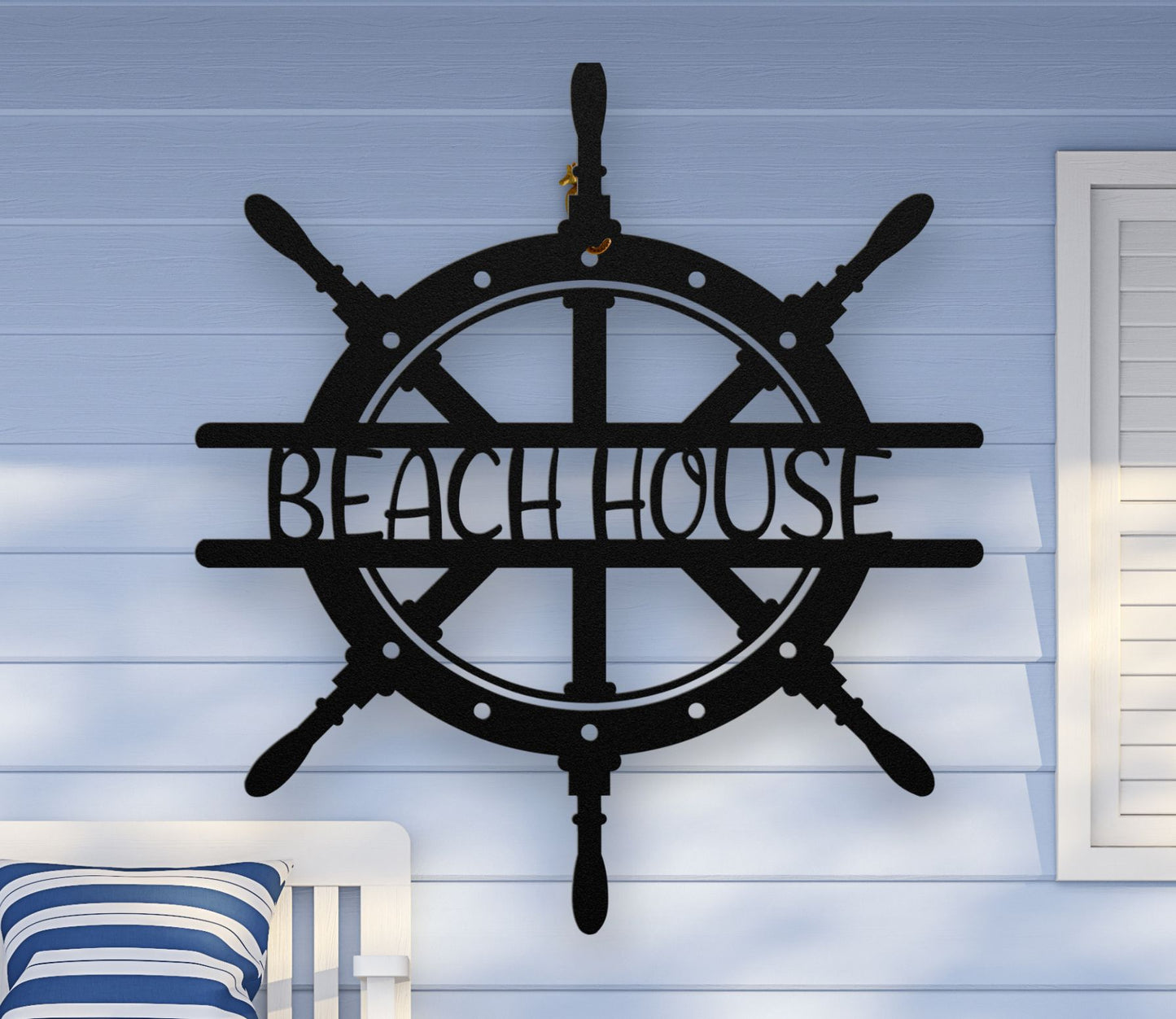 Black metal wall art shaped like a ship wheel with the words “Beach House” cut out in the center, available in multiple colors and sizes.