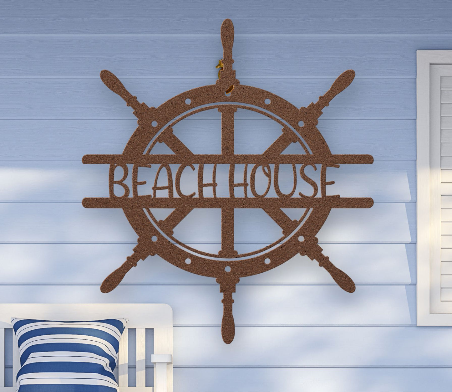 Copper metal wall art shaped like a ship wheel with the words “Beach House” cut out in the center, available in multiple colors and sizes.