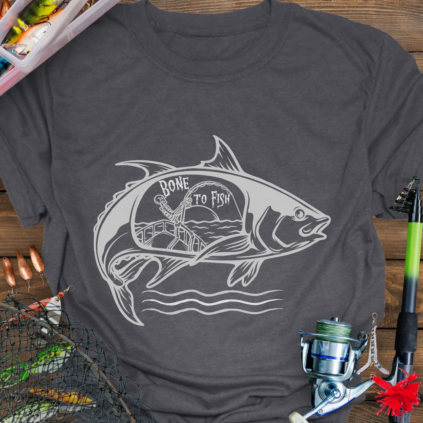 Dark Heather T-shirt with “Bone for Fishing” text inside a large fish silhouette containing a skeleton fishing off a boat, gothic nautical design for anglers.