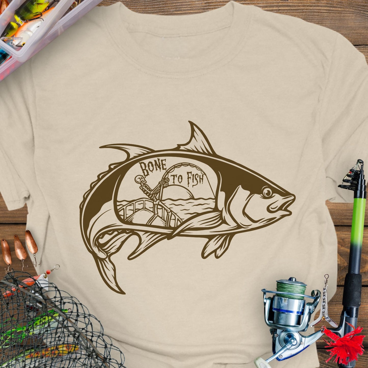 Natural T-shirt with “Bone for Fishing” text inside a large fish silhouette containing a skeleton fishing off a boat, gothic nautical design for anglers.