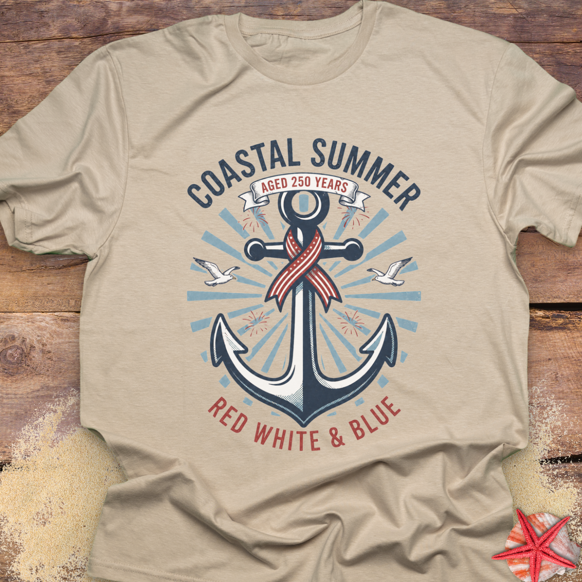 Beige t-shirt with an anchor design and 'Coastal Summer' text on a wooden surface.