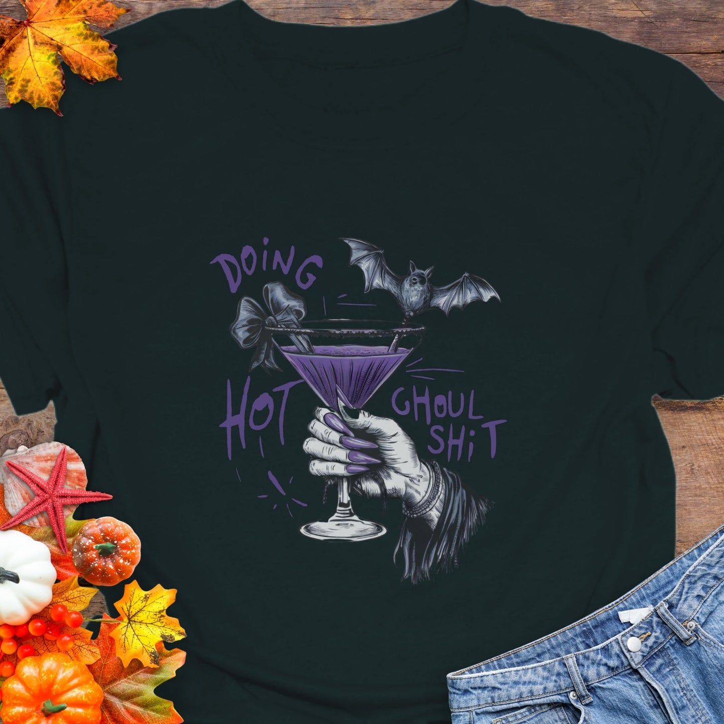 Black t-shirt with Halloween-themed design featuring a hand holding a martini glass with a bat and text.