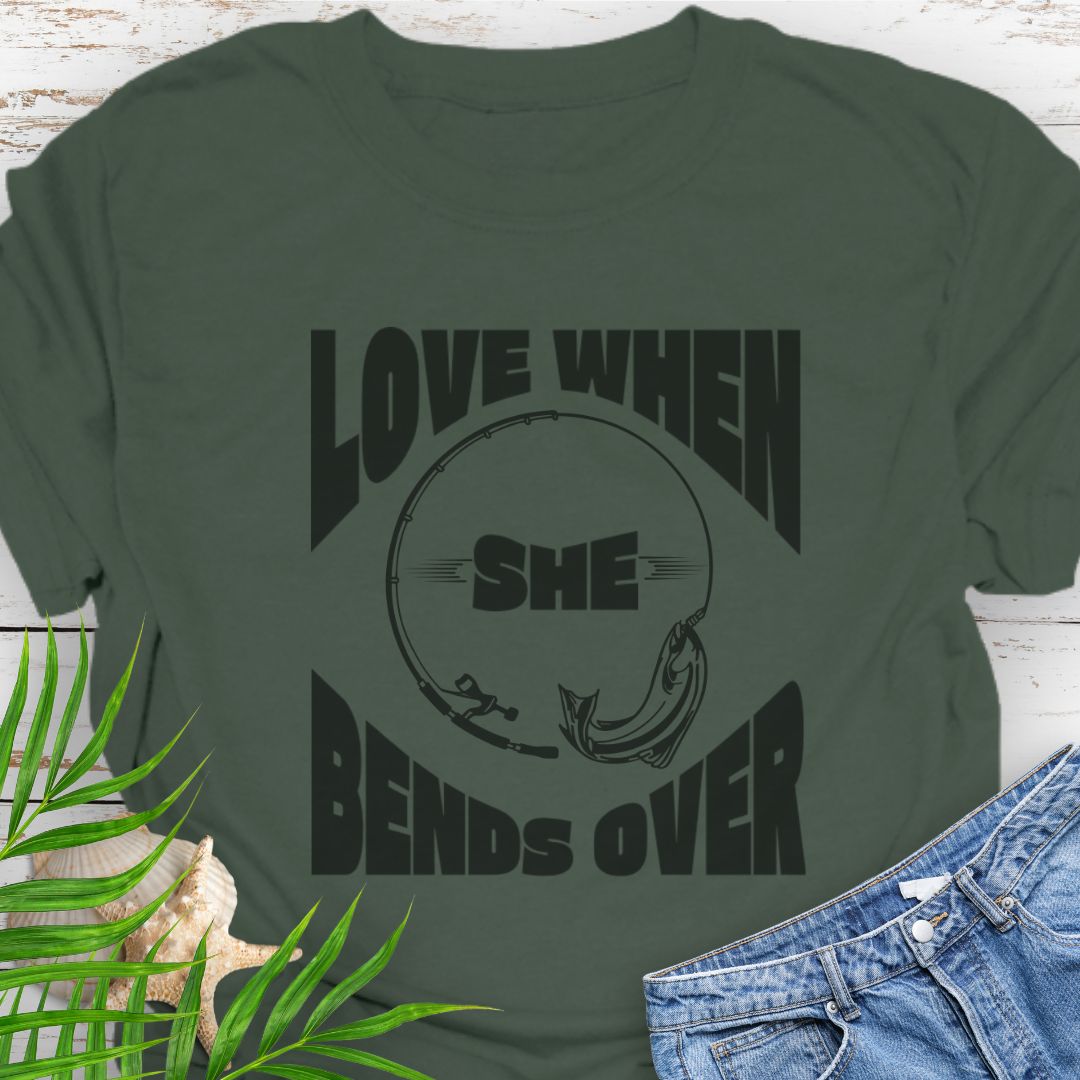 Military Green T-shirt with a fishing pole bending over and the phrase “Love When She Bends Over” – humorous fishing design for anglers