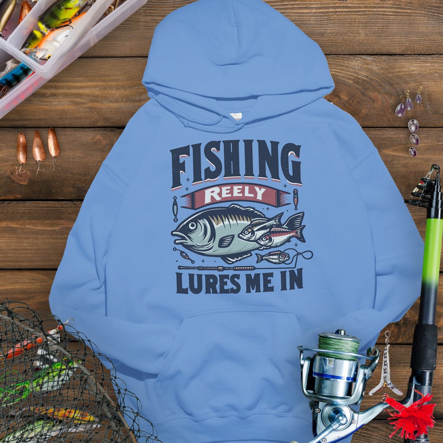Columbia Blue fishing hoodie with fish and tackle graphics and the phrase “Fishing Reely Lures Me In”.